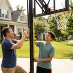 自宅の庭でバスケットゴールの高さを調節する親子