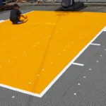 家族でスポーツタイルをアスファルトの上に敷いている様子